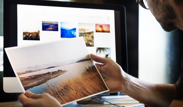 Photographer looking at his final proof, a lovely photograph of an estuary
